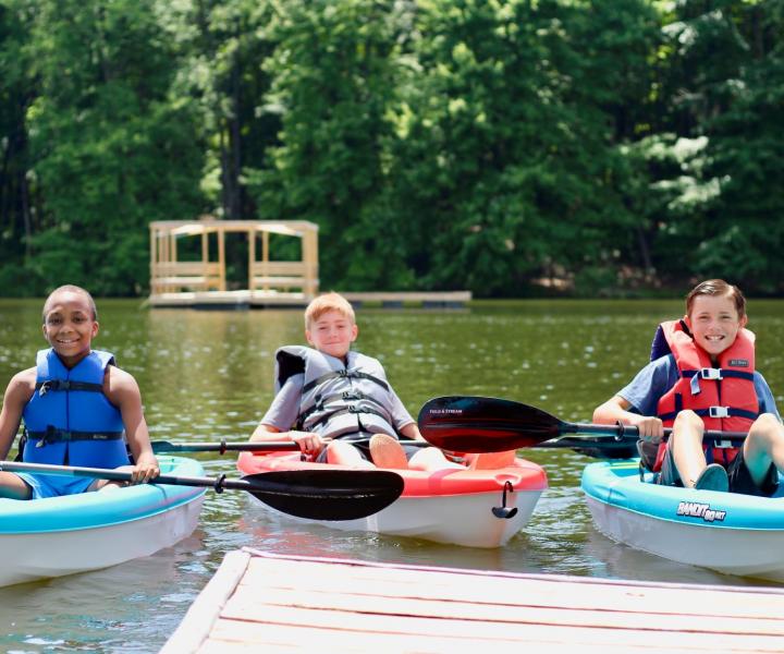 three boys on kayaks